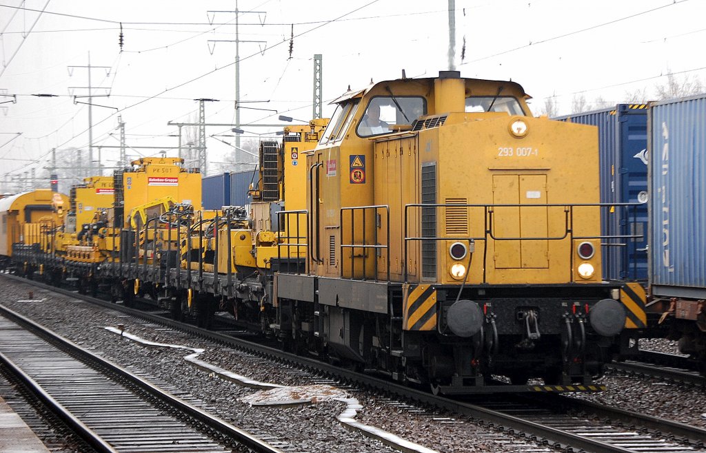 Die DB Bahnbau Gruppe (DGT) f�hrt mit einem Gleisbauzug gezogen von 293 007-1  Lok !  (92 80 1293 007-1 D-DGT, LEW Bj.1983) und meheren Spezialwagen mit Maschinen zur Schienenbearbeitung und 92 80 1293 011-3 durch den Bhf. Flughafen Berlin-Sch�nefeld, 16.01.12