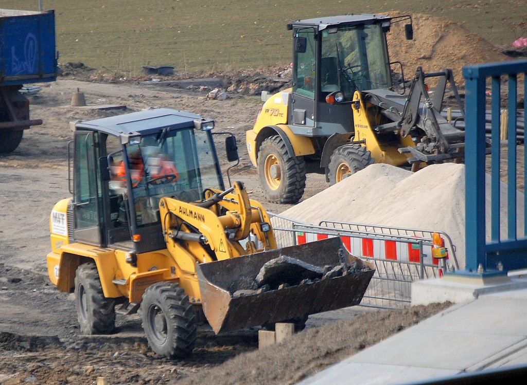 Ein AHLMANN AS70 Radlader und dahinter ein NEW HOLLAND W70TC Radlader an der Gro�baustelle neben dem S-Bhf. Berlin-Adlershof.