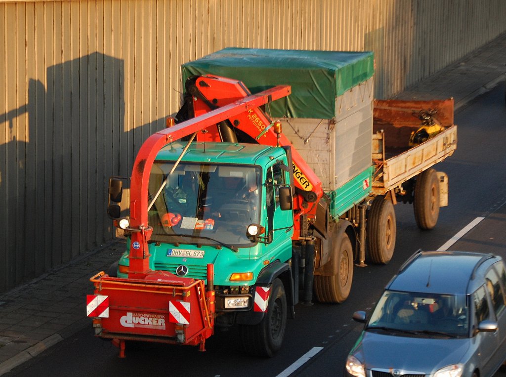 Ein MB Unimog mit einem Randstreifenm�hger�t(d�cker GmbH) vor der Front und PALFINGER Typ PK 26502 Hydraulikgreifarmaufsatz mit H�nger, 18.10.10 Berliner Stadtautobahn H�he Knobelsdorffstr. 
