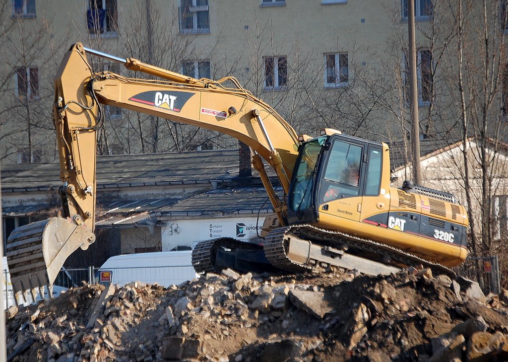 Leasingbaumaschine, ein CAT 320C Raupenbagger erklimmt einen Schutth�gel, 01.03.11 Gro�baustelle gegen�ber dem S-Bhf. Berlin Frankfurter Allee.