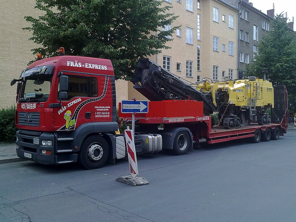 MAN Zugmaschine mit Tiefladebr�ckenauflieger mit der Asphaltfr�se BOMAG BM 1000/30 der Fa. FR�S-EXPRESS aus Berlin, 11.06.12 Berlin-Pankow.