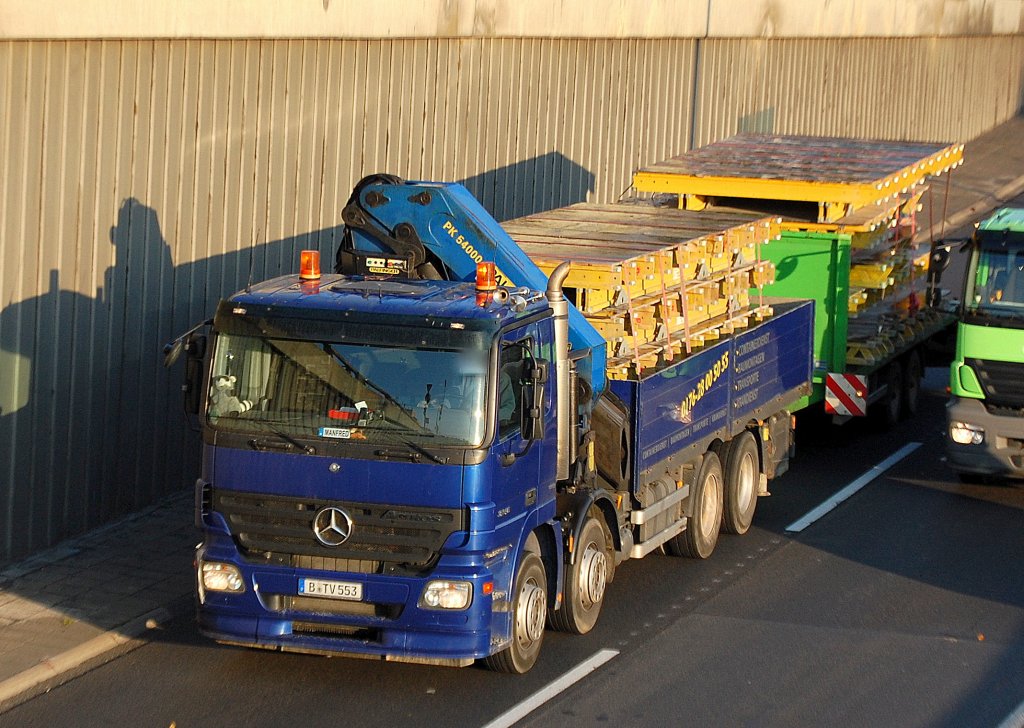 MB ACTROS 3240, ein vierachsiger Baulaster in tollem Blau mit pritschenumrandeter Ladefl�che und PALFINGER Typ PK 54000 Hydraulikgreifarmaufsatz beladen mit Verschalungs-Fertigelementen + H�nger, 18.10.10 Berlin Stadtautobahn H�he Knobelsdorffstr.