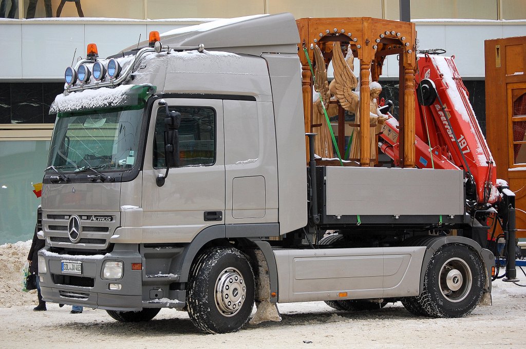 MB ACTROS mit kurzer Ladefl�che und Hydraulikgreifarmaufsatz als Zugmaschine eines Schaustellerbetriebes bei den Abbauarbeiten des Weihnachtsmarktes am Berliner Alexanderplatz, auf der Ladefl�che ein Holzengel, 28.12.10 