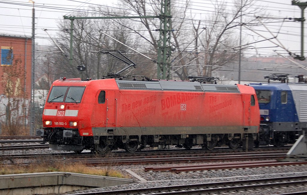 Schon l�ngere Zeit an die RBH vermietet, die DB Lok 185 002-8 (91 80  6185 002-3 D-DB) als RBH 235, hier hat sie RBH 119 + 107 + Kesselwagenzug am Haken Richtung Berlin Wedding, 26.01.11 Berlin-Westhafen. Der ehemalige Bombardier Werbeslogan zeichnet sich auf dem roten Untergrund noch etwas ab.