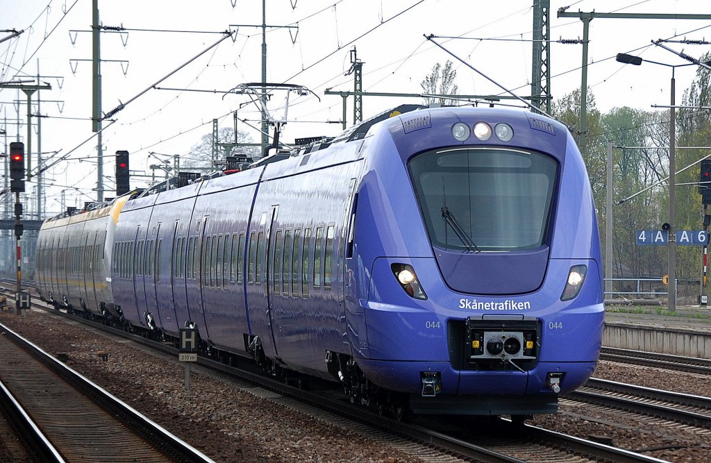 Selbst�berf�hrung Richtung Ostsee (Rostock) zu den F�hren nach Schweden, die neuen vierteiligen Triebz�ge von Alstom der Serie Alstom Coradia Nordic X61 - X62, im Vordergrund der lilaf�rbende Triebzug 044 f�r Skanetrafiken und hintendran in silber-gelb ein Triebzug f�r V�sttrafik am 25.04.12 bei der Durchfahrt im Bhf. Flughafen Berlin-Sch�nefeld.   