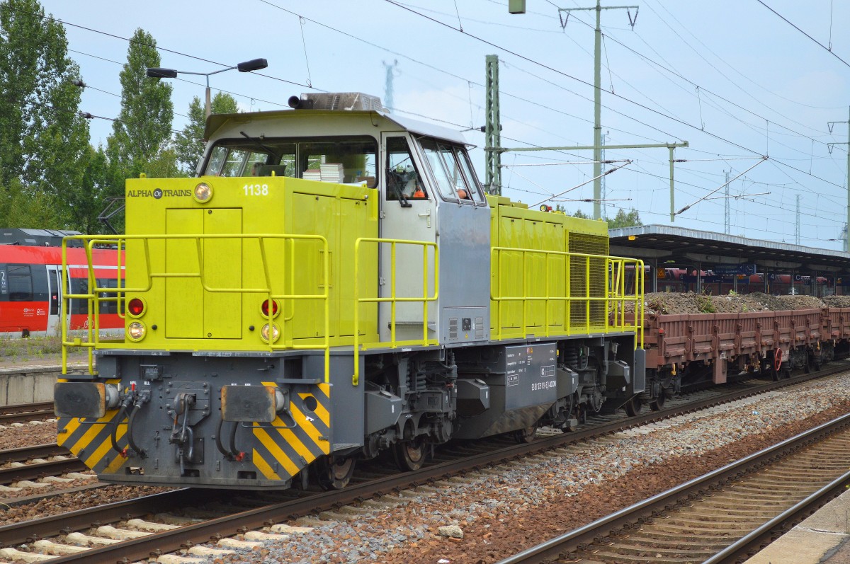 Alpha Train Mietlok 1138 (275 119-6) von LOCON mit einem Ganzzug Drehgestell-Flachwagen mit altem Gleisschotter befüllt bei der Durchfahrt im Bhf. Flughafen Berlin-Schönefeld, 07.08.14