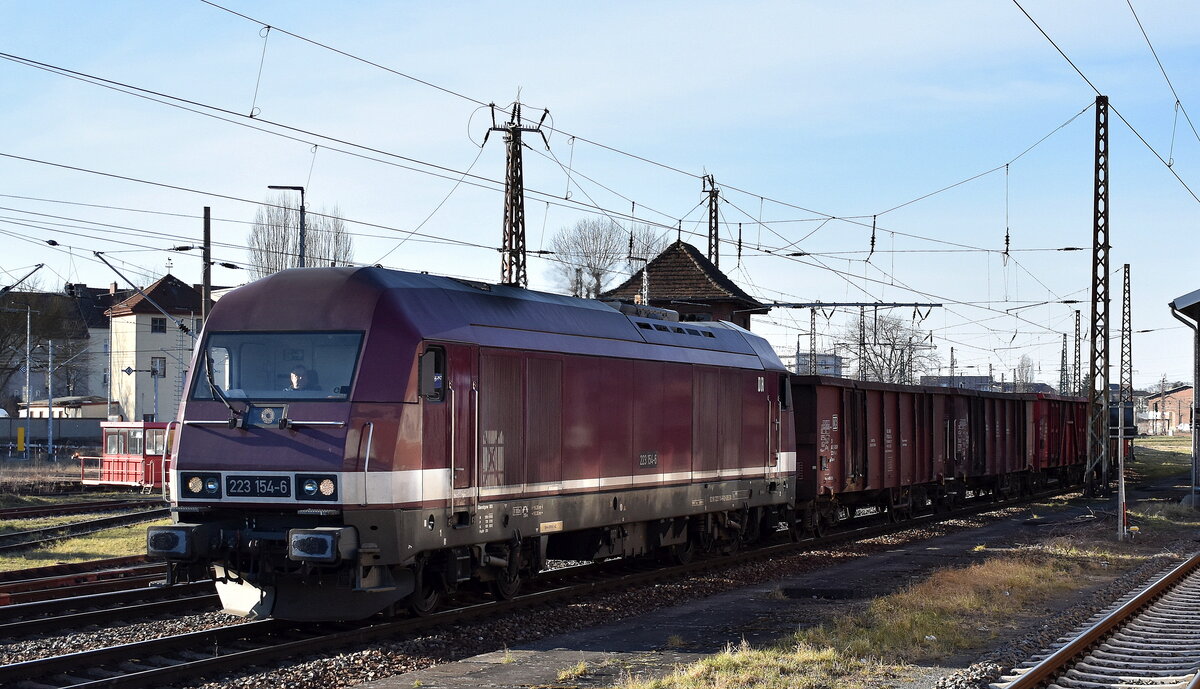 DeltaRail GmbH, Frankfurt (Oder) mit ihrer  223 154-6  (NVR:  92 80 1223 154-6 D-DELTA ) kommt mit einem Ganzzug polnischer DB Cargo Drehgestell-Hochbordwagen (leer) Höhe Bahnhof Frankfurt (Oder) an u. wird abgespannt, 04.03.25