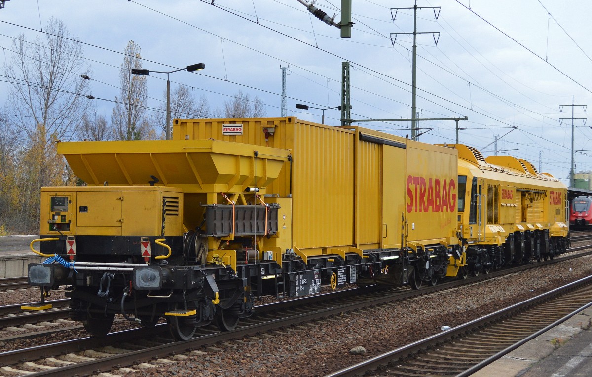 Der Schienfräszug vom Hersteller Linsinger Typ SF03 W-FFS (Bj.2010) der FA. STRABAG  Hannibal  mit dem Begleitwagen (Drehgestell-Flachwagen Typ Res) mit Arbeitscontainern und Silobehältnis für Metallspäne der Fa.BMTI Rail Service GmbH einer Tochterges. von STRABAG mit der Nr. 37 RIV 80 D-BRS 3999 115-3 Res am 09.11.15 Bhf. Flughafen Berlin-Schönefeld.