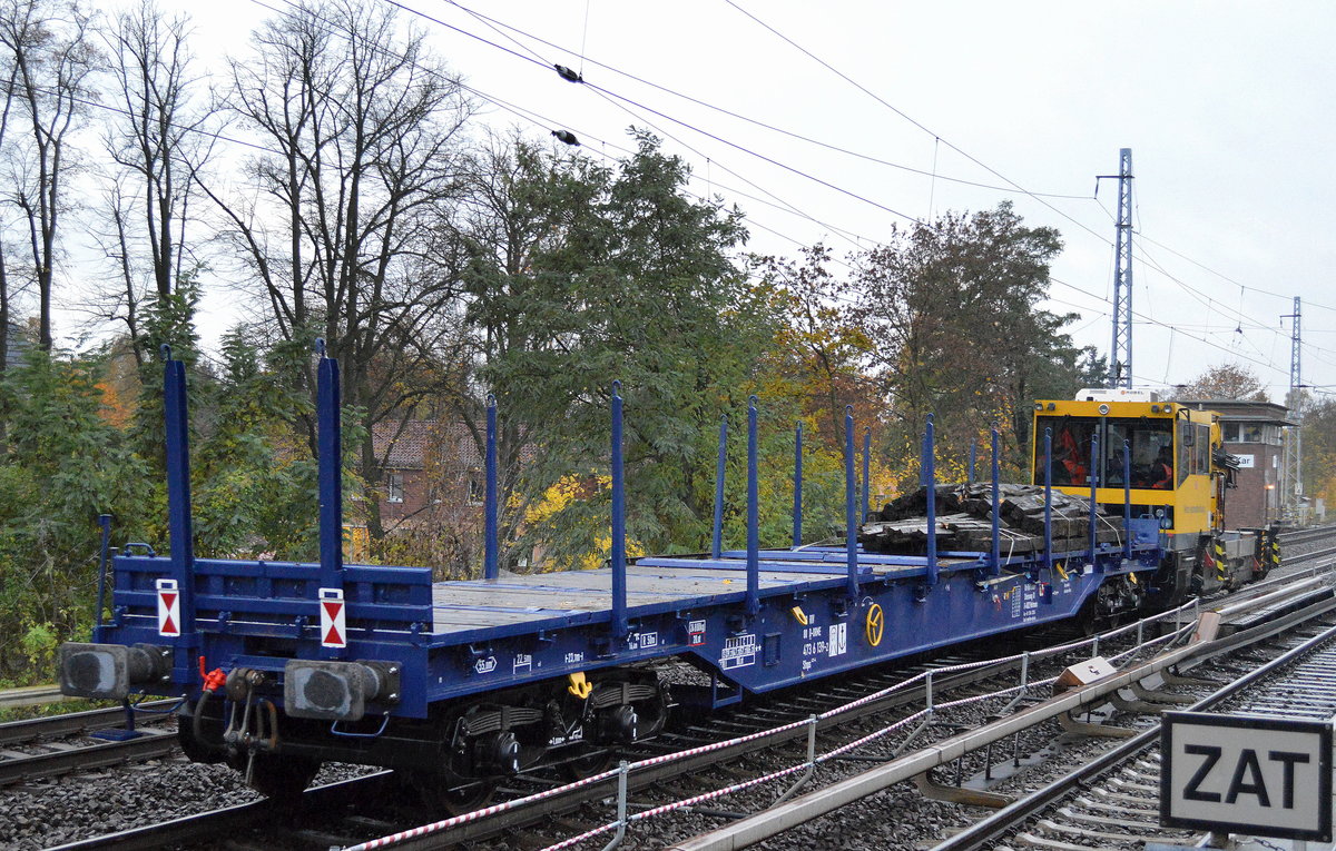 Dieser Drehgestell-Flachwagen mit Rungen der Wagengattung Sfnps ist ein sogenannter fährbootfähiger Rungenwagen und aus dem Fuhrpark vom Einsteller On Rail GmbH, hier am Haken eines BAMOWAG der DB Bahnbau Gruppe, er trägt die Nr. 83 RIV 80 D-ORME 473 6 139-2 Sfnps 473-4 und ist mit einigen alten Holz-Bahnschwellen beladen, 01.11.16 Berlin-Karow.