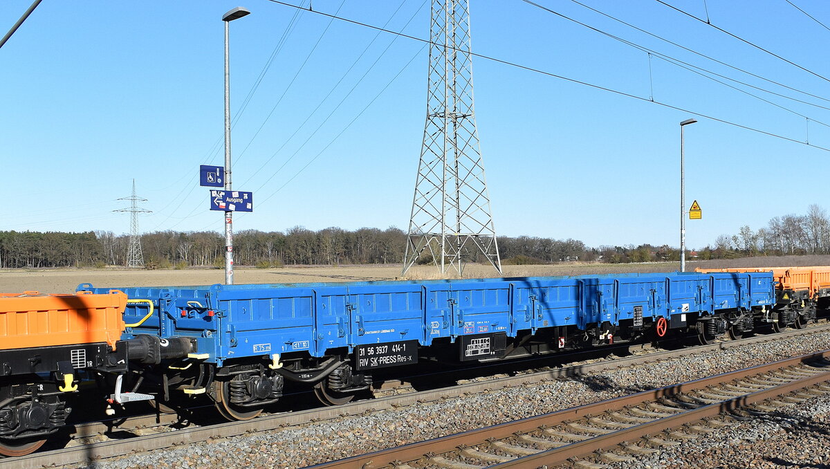 Drehgestell-Flachwagen mit  Stahlfußboden, Seiten- und Stirnwänden vom Einsteller PRESS mit slowakischer Registrierung mit der Nr. 31 RIV 56 SK-PRESS 3937 414-1 Res-x in einem Ganzzug am 18.03.25 Höhe Bahnhof Rodleben.