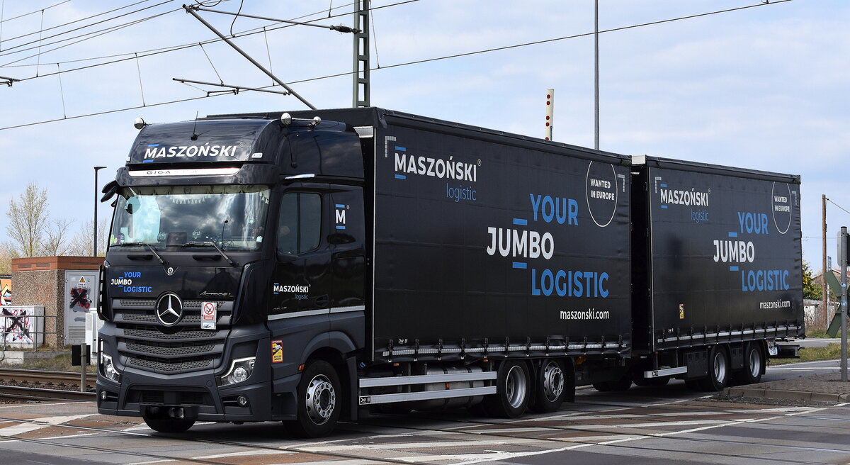 MCG Logistics dawniej Maszoński Logistic aus Polen mit einem MB ACTROS L 2545 Jumbo Pritschenaufbau Hängerzug am 09.04.25 Höhe Bahnübergang Rodleben.