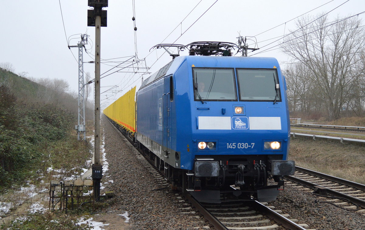 PRESS 145 030-7 (145 085-7) mit einem der typisch gelb leuchtenden Rungenwagenzüge für Stammholz-Transporte (leer) am 25.01.17 Durchfahrt Bf. Berlin-Hohenschönhausen.