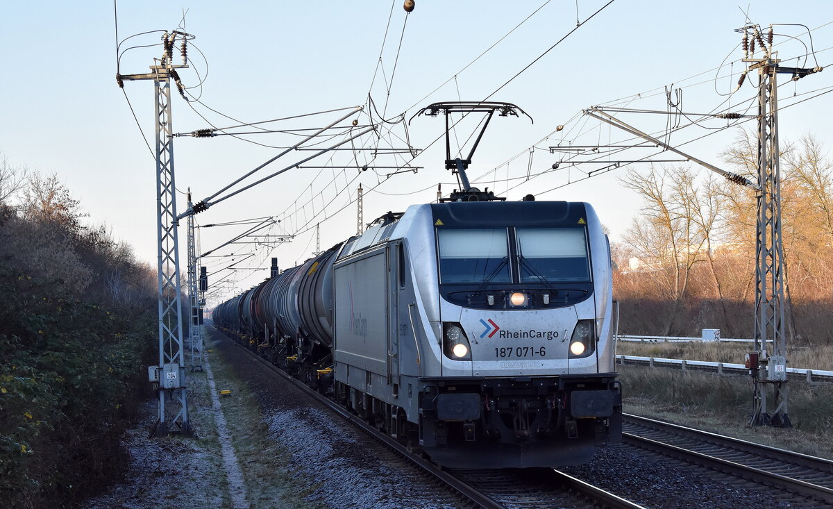 RheinCargo GmbH & Co. KG, Neuss [D]  mit ihrer  187 071-6  [NVR-Nummer: 91 80 6187 071-6 D-RHC] und einem Kesselwagenzug aus dem PCK Schwedt am 17.12.25 Durchfahrt Bahnhof Berlin-Hohenschönhausen.