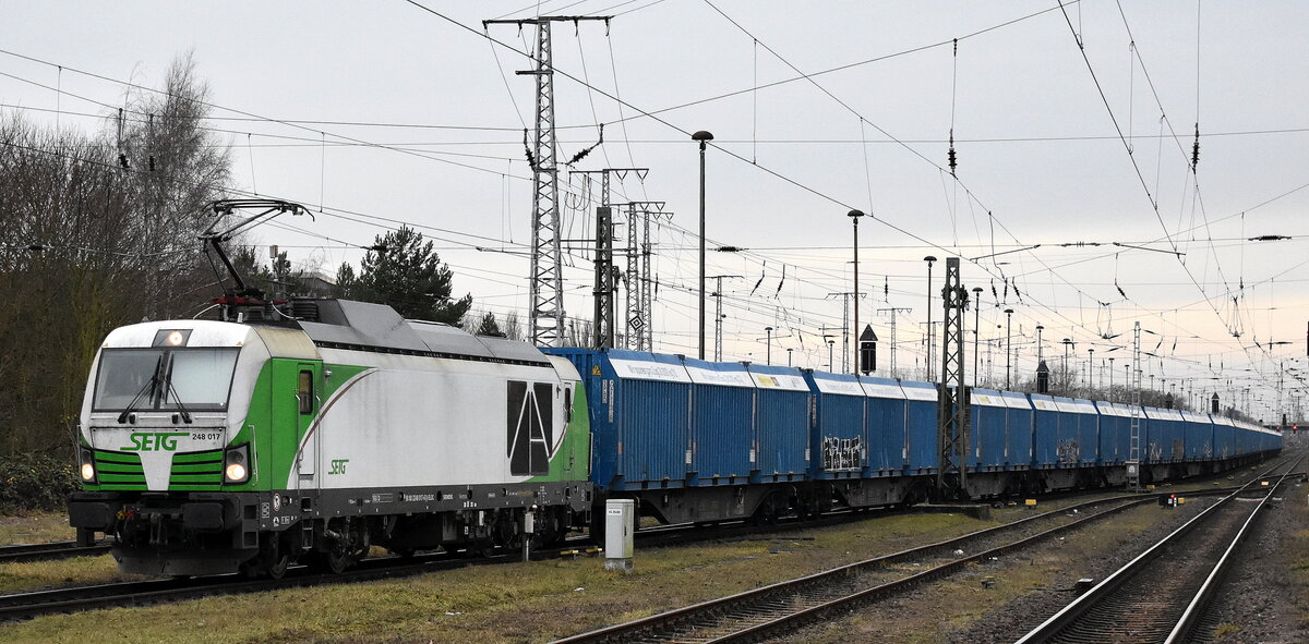 Salzburger Eisenbahn Transport Logistik GmbH, Salzburg [A] mit der geleasten ELL Vectron Dual Lok  248 017  [NVR-Nummer: 90 80 2248 017-6 D-ELOC] und einem Ganzzug Container für Holzhackschnitzel am 10.12.25 Höhe Bahnhof Stendal Hbf. 