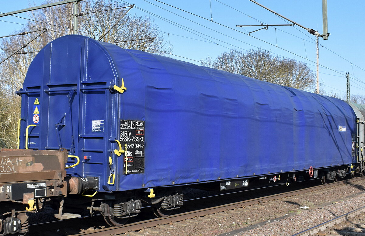 Slowakischer  Drehgestellflachwagen mit vier Radsätzen, verschiebbarem Planenverdeck von AXBENET vermietet an ZSSK Cargo mit der Nr. 31 RIV 56 SK-ZSSKC 3542 094-8 Rils  in einem gemischten Güterzug am 27.03.25 Höhe Bahnhof Niederndodeleben.