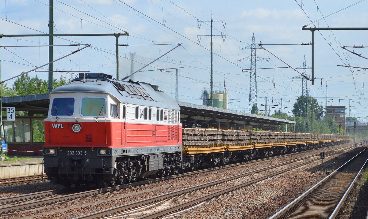 WFL 232 333-5 mit einem Ganzzug Oberbaustoffwagen mit Fertigbetonschwellen am 30.06.15 Durchfahrt Bhf. Flughafen Berlin-Schönefeld.