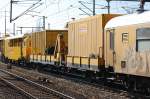Diverse Flachwagen mit Bau- und Werzeugcontainern in einem Gleisschotterreinigungszug der DB Bahnbaugruppe am 22.03.12 Bhf.