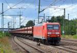 145 048-5 mit Ganzzug Schüttgutkippwagen bei der Durchfahrt Bhf.