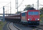 155 212-4 mit einem Ganzzug Sch�ttgutkippwagen mit Kies bei der Durchfahrt im Bhf.