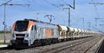 Havelländische Eisenbahn AG, Berlin-Spandau [D] mit ihrer Eurodual Lok  159 010  [NVR-Nummer: 90 80 2159 010-8 D-HVLE] und einem Schüttgutwagenzug mit Sand am 09.04.25 Höhe Bahnhof
