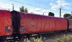 Drehgestell-Flachwagen mit vier Radsätzen, mit verschiebbarem Planenverdeck und mit Rungen der DB Cargo, der Wagen ist für den Transport von nässeempfindlichen, palettierten und