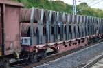 Österreichischer Drehgestell-Flachwagen mit Rungen und Spezialaufsatz für Drahtrollen vom Typ Rns-z der ÖBB mit einigen gleichartigen Güterwagen in einem gemischtem Güterzug