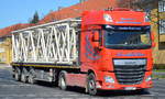 Moderne DAF XF 510 Zugmaschine mit Flachtrailer mit Hockkransegmenten beladen der Fa.