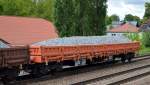 Drehgestell-Flachwagen mit Seitenborden mit Schotter beladen vom Einsteller NACCO mit der Nr.